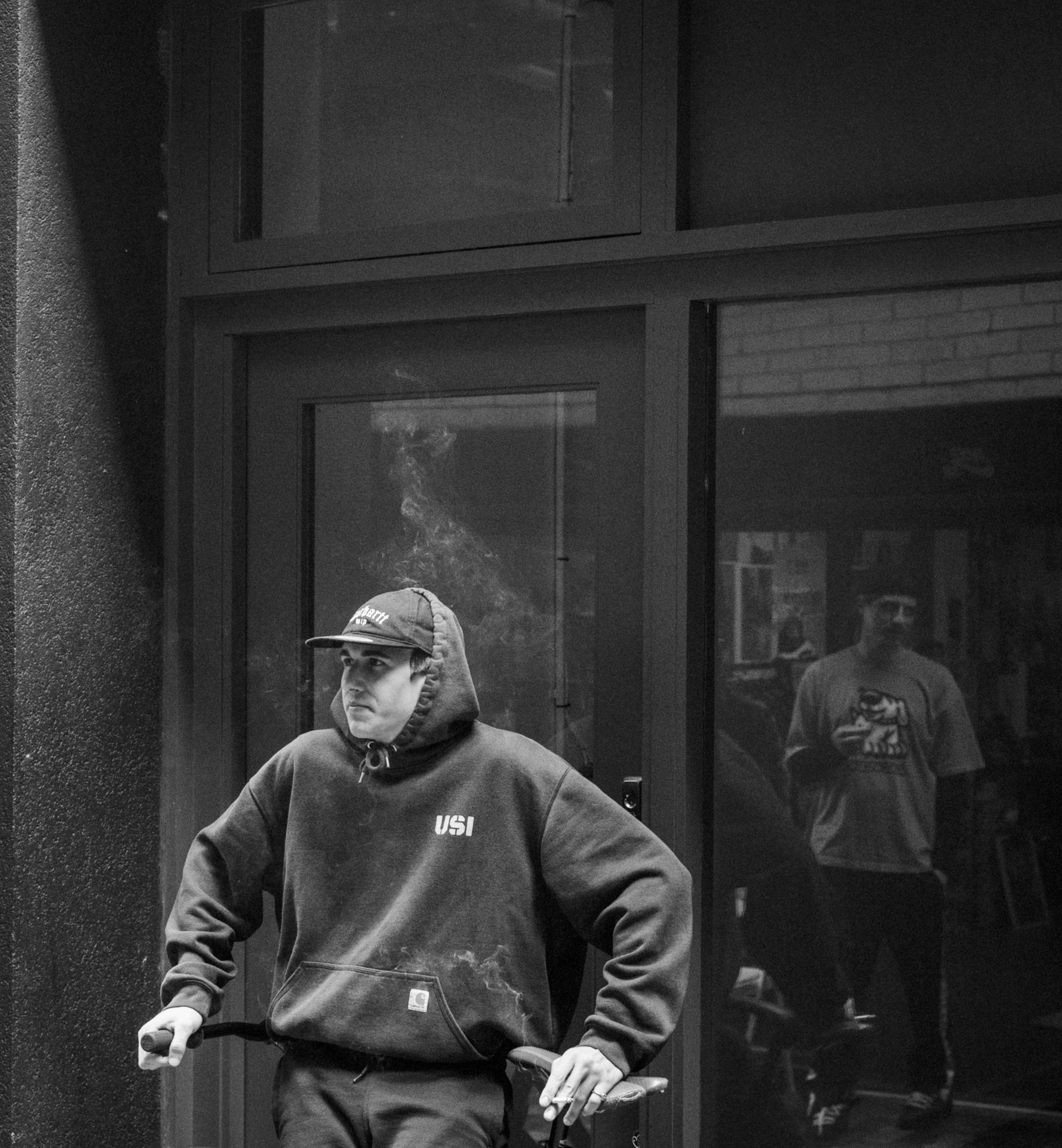 Guy leaning with mirrors behind in black and white