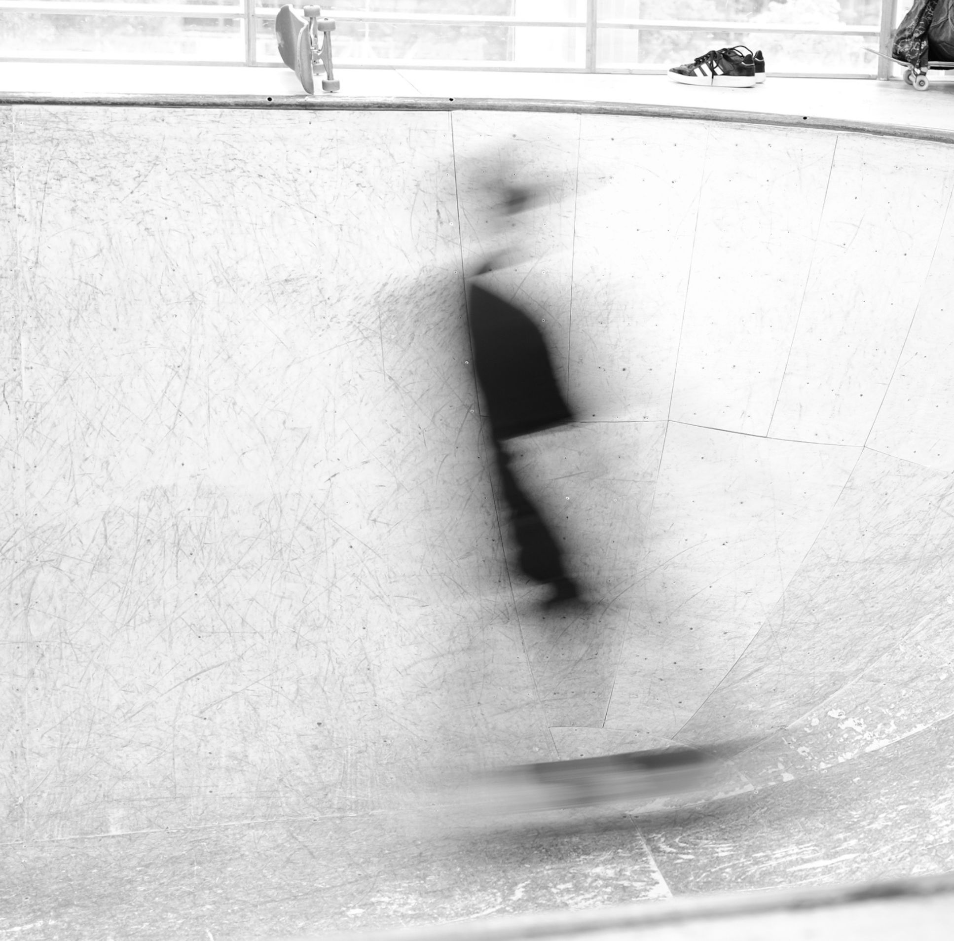 Skateboard park in london with a guy riding a skate in black and white