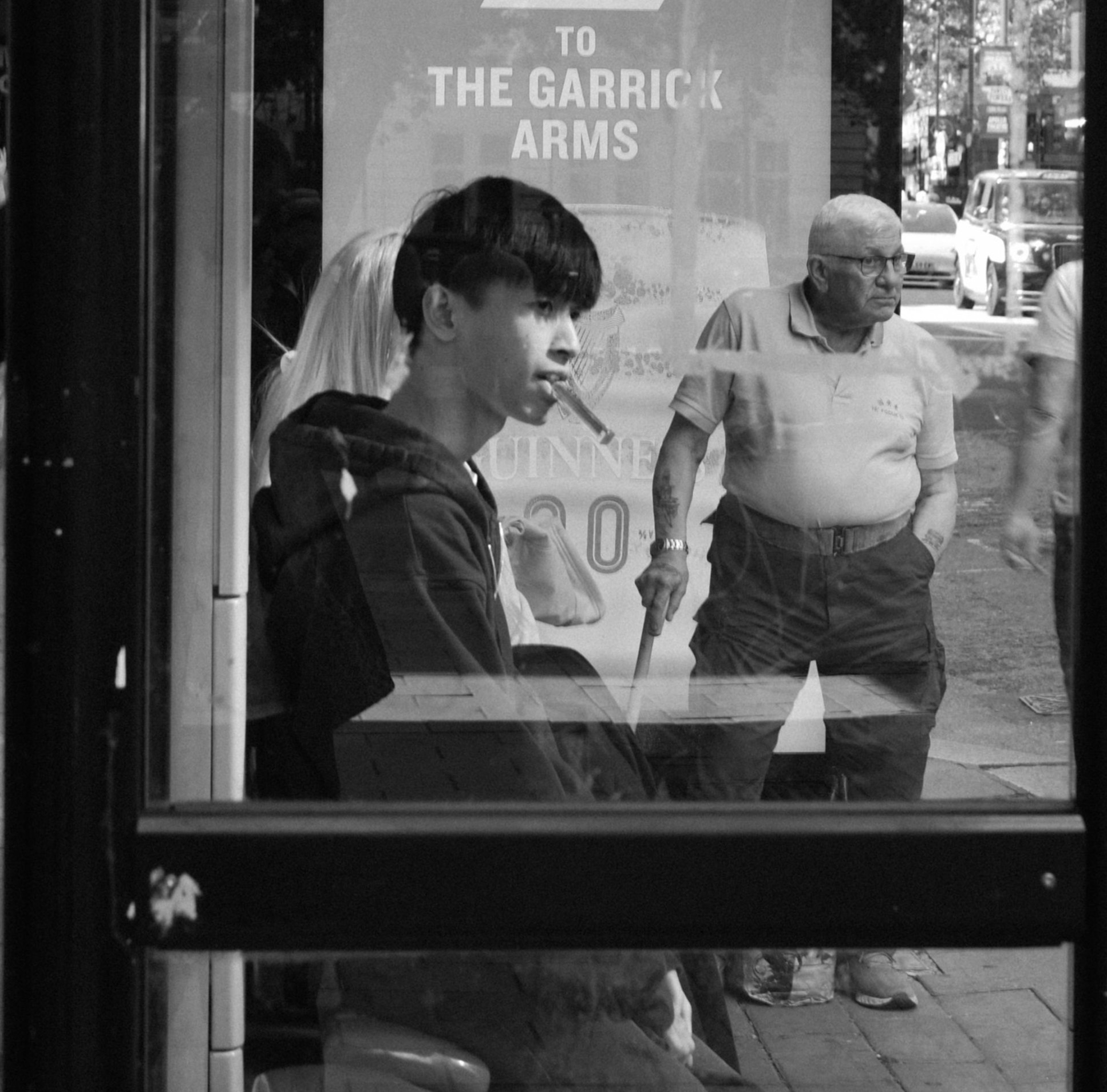 Man and a boy waiting at the station in black and white